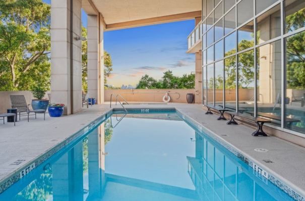 Rooftop lap pool at a high-rise building with a glass wall and the Atlanta skyline in the distance